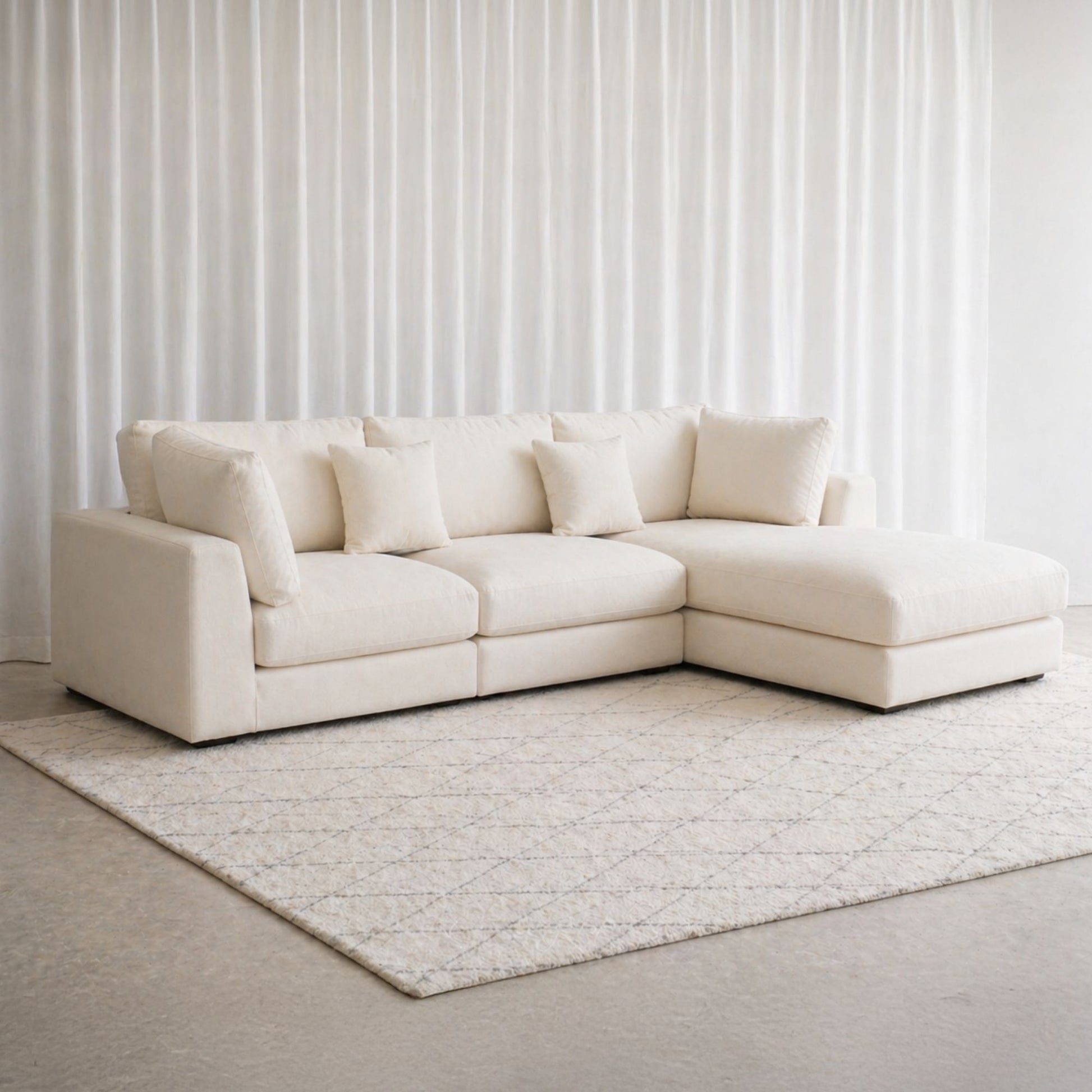 White sectional sofa in a room with light-colored walls and rug.