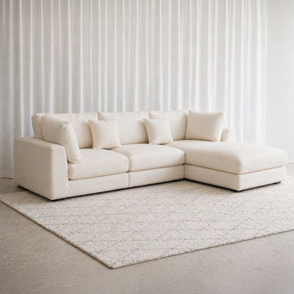 White sectional sofa in a room with light-colored walls and rug.