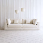Claudia 4 seater white fabric sofa in living room setting with rug and coffee table