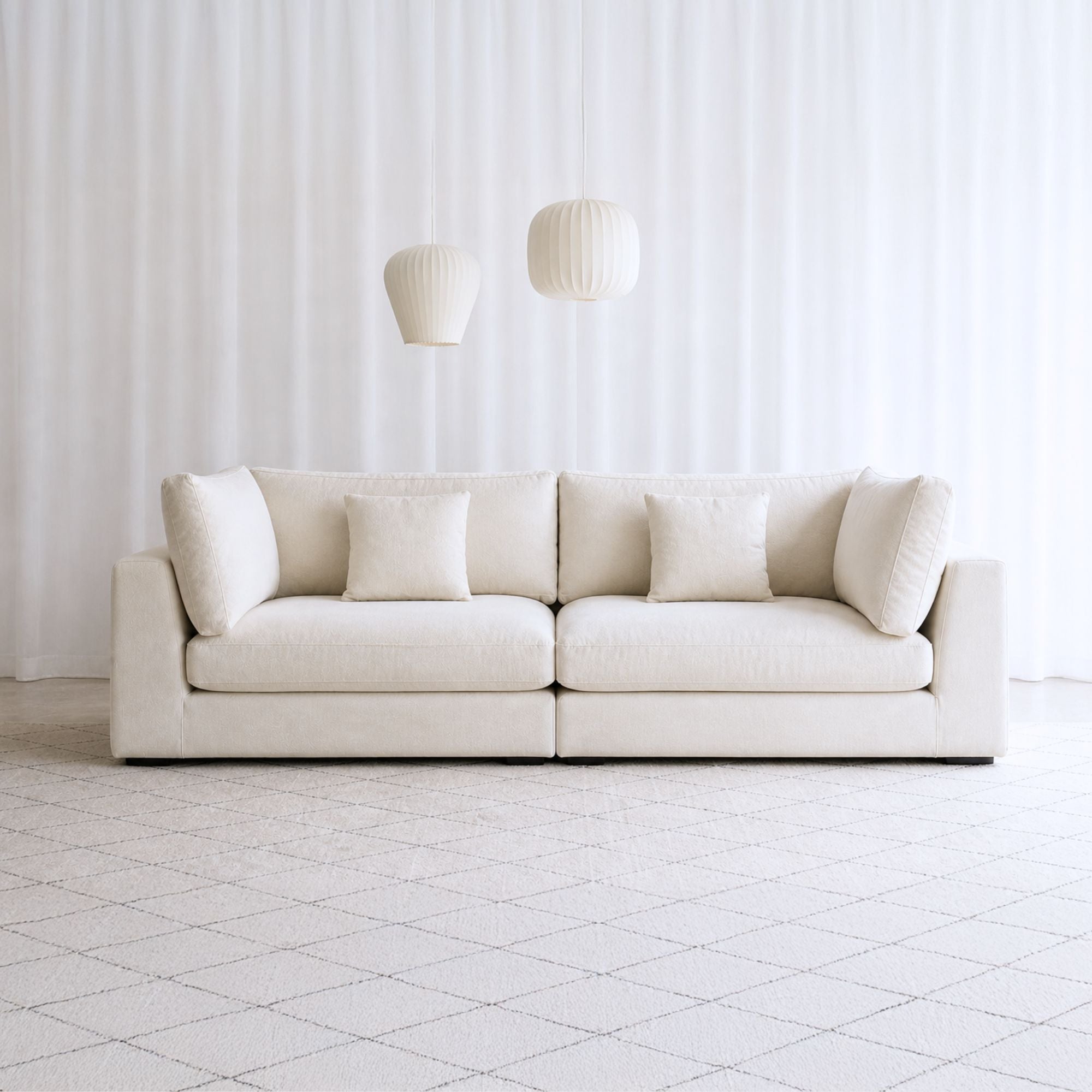 Claudia 4 seater white fabric sofa in living room setting with rug and coffee table
