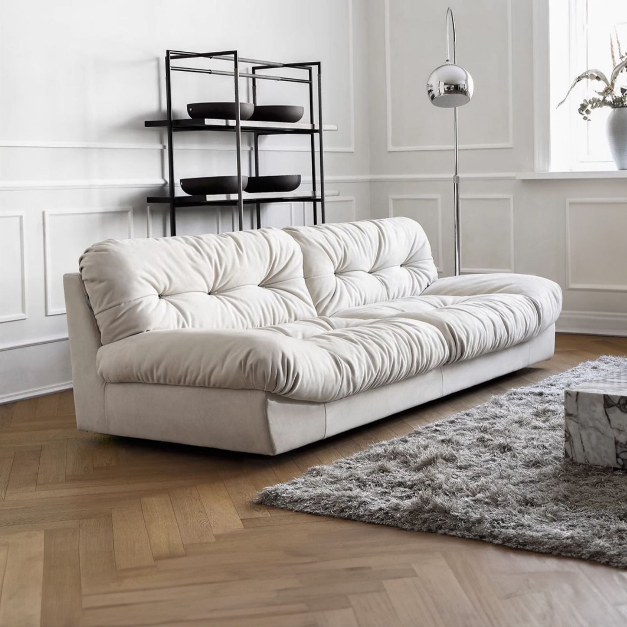 White sofa in a modern living room with a rug and decorative items.
