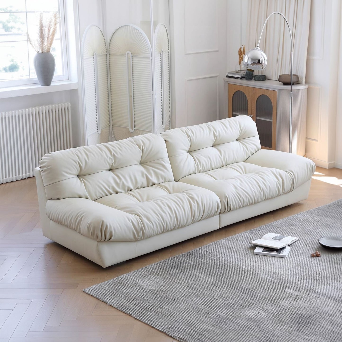 White sofa in a modern living room with a rug and decorative items.
