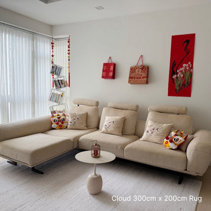 Beige sectional sofa in a living room with decorative pillows and a small table.