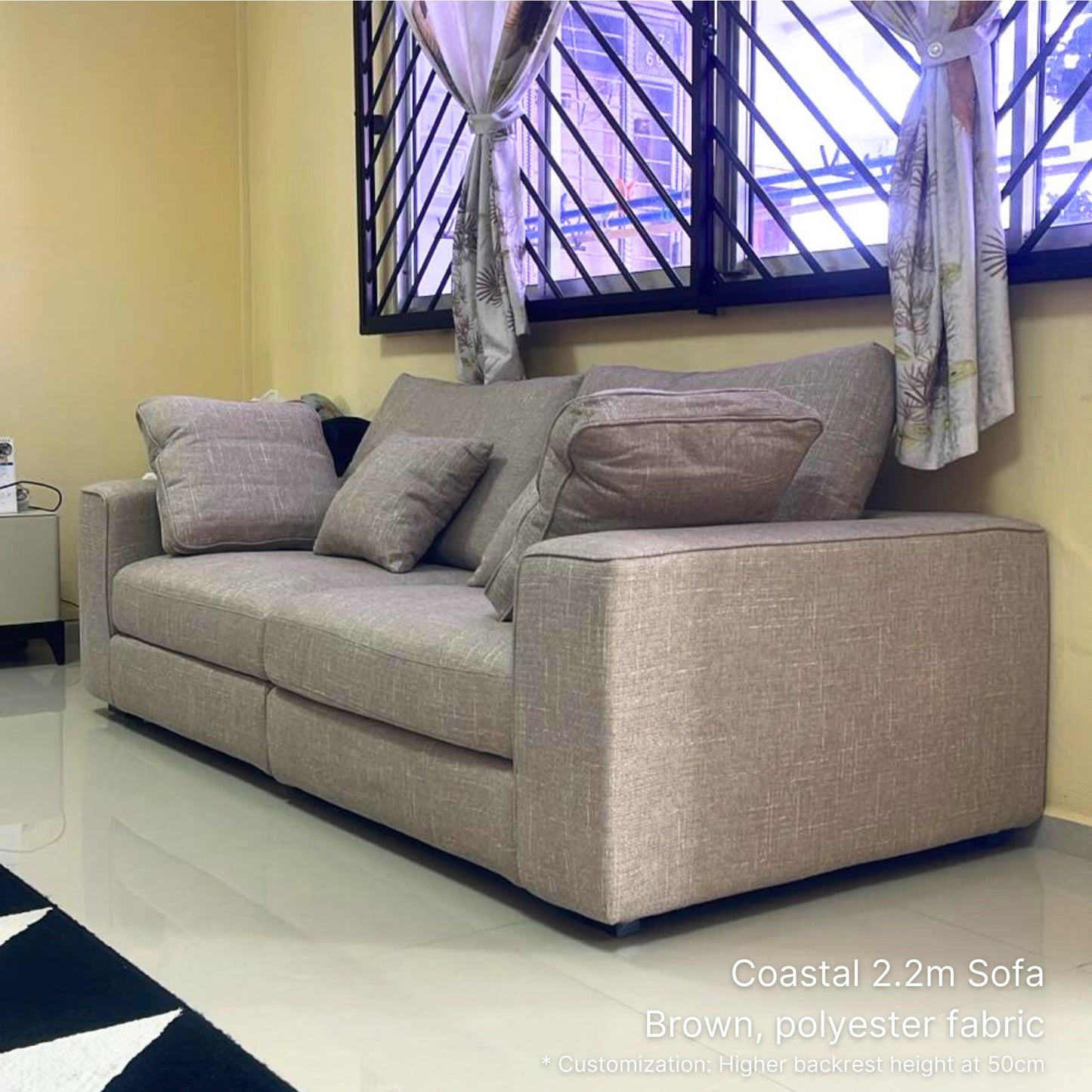 3 seater 220cm brown Coastal fabric sofa with brown cushions in a room with a window and curtains.