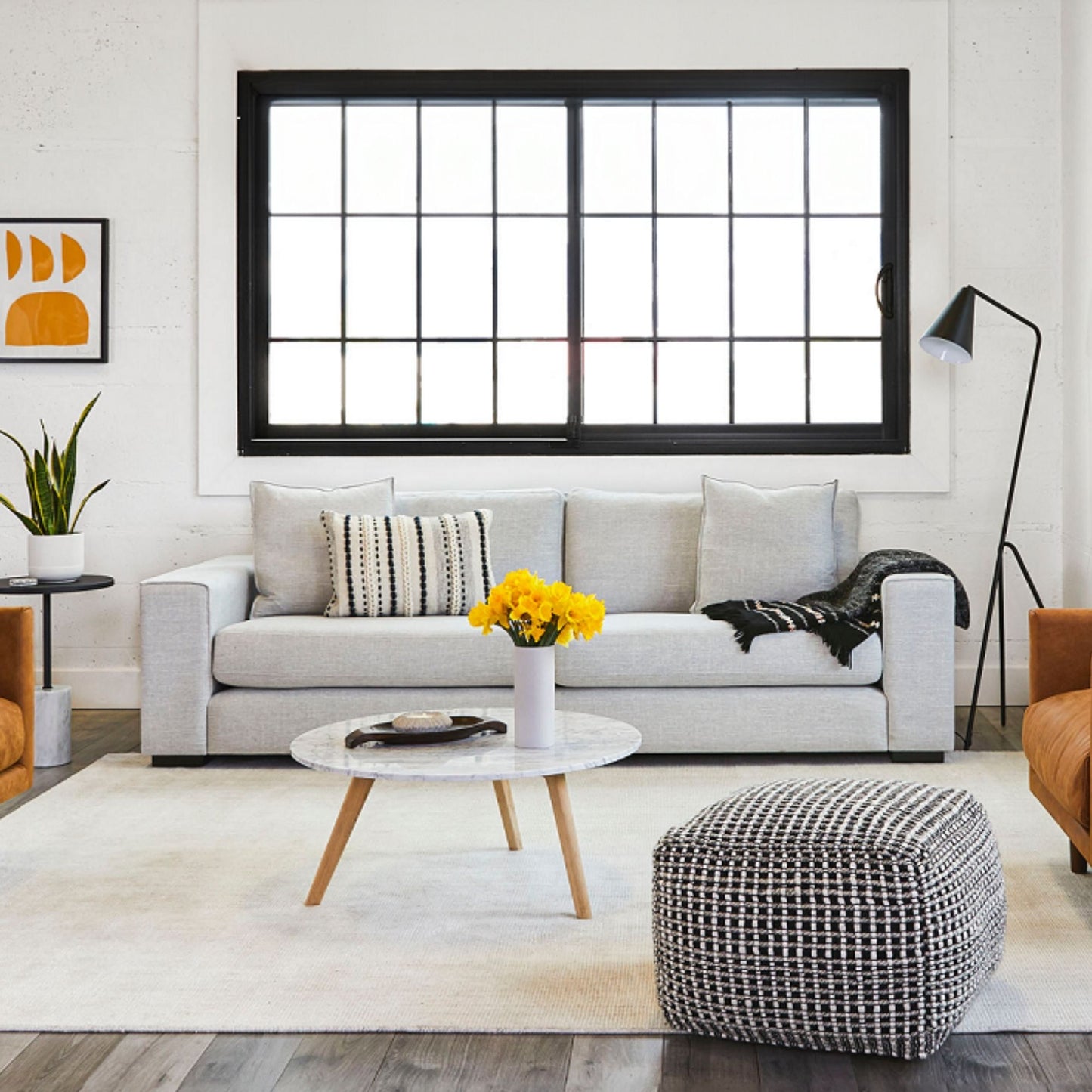 Modern living room with a gray sofa, coffee table, and decorative elements.