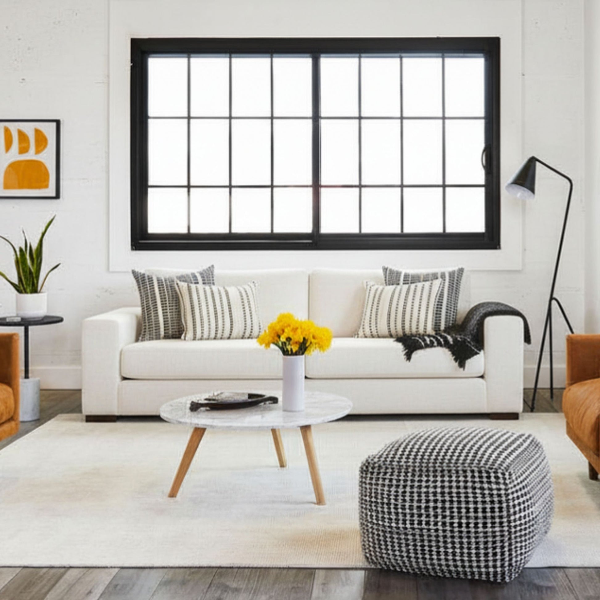 Modern living room with white sofa, coffee table, and decorative elements.