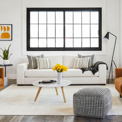 Modern living room with white sofa, coffee table, and decorative elements.