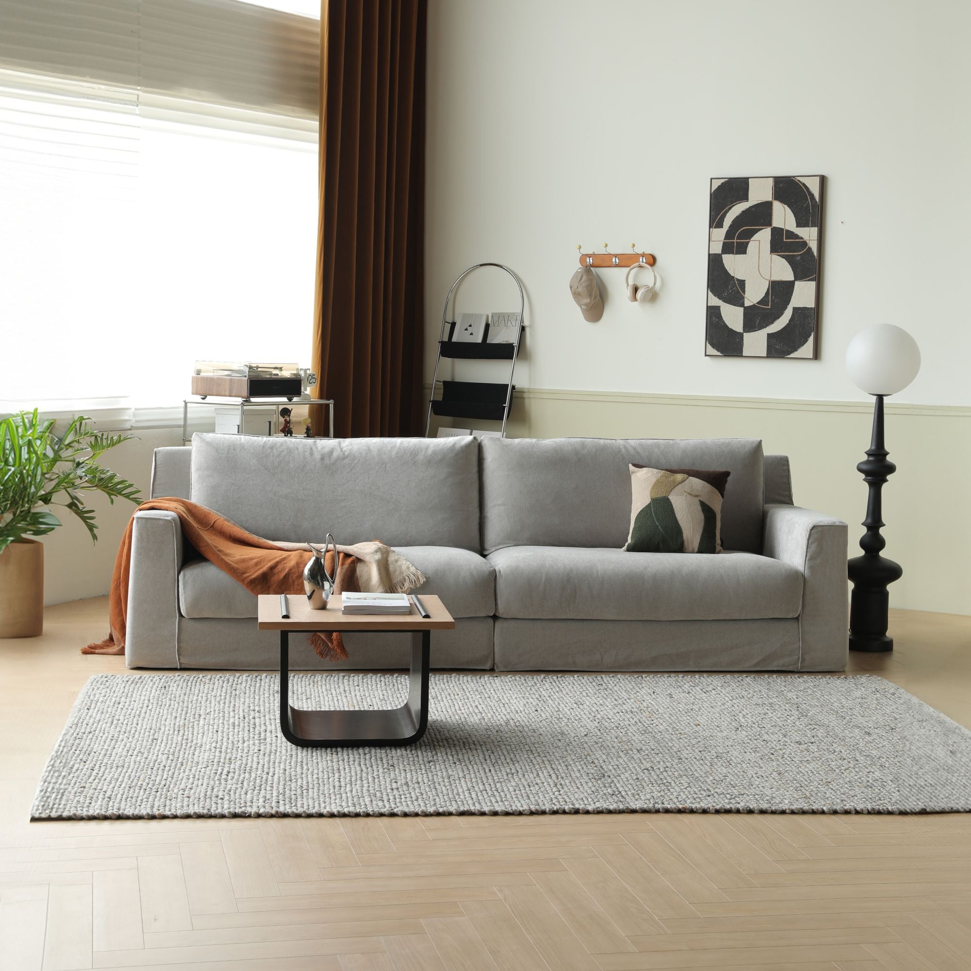 Modern living room with a gray sofa, coffee table, and decorative items.