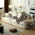 Modern living room with a off white sofa, decorative pillows, and a rug.