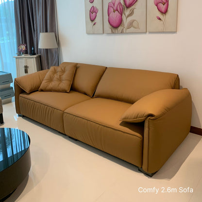 Brown 4 seater Comfy half leather sofa in a living room with floral artwork on the wall.