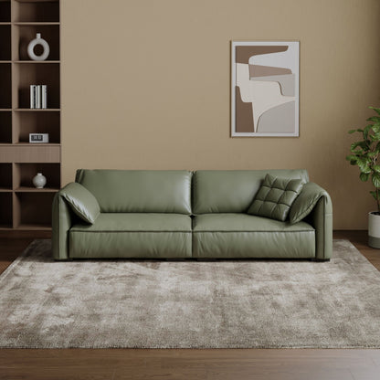 Green sofa in a living room with a abstract painting on the wall.
