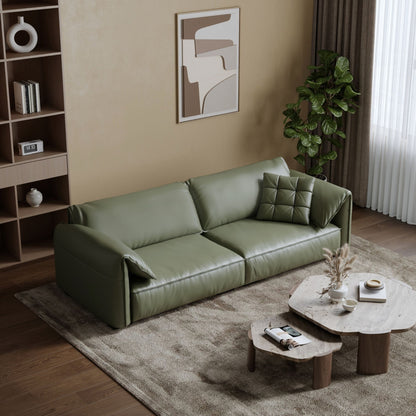 Green sofa in a living room with a coffee table and decorative items.