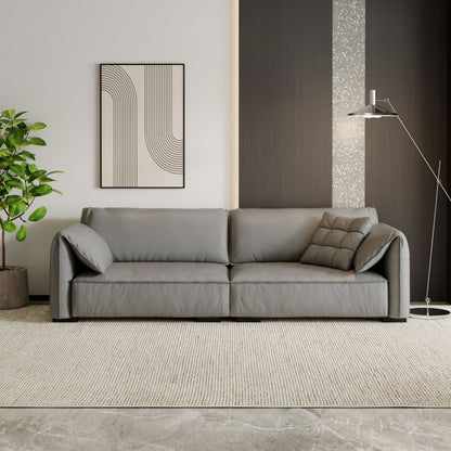 Gray sofa in a modern living room with a plant and abstract art on the wall.