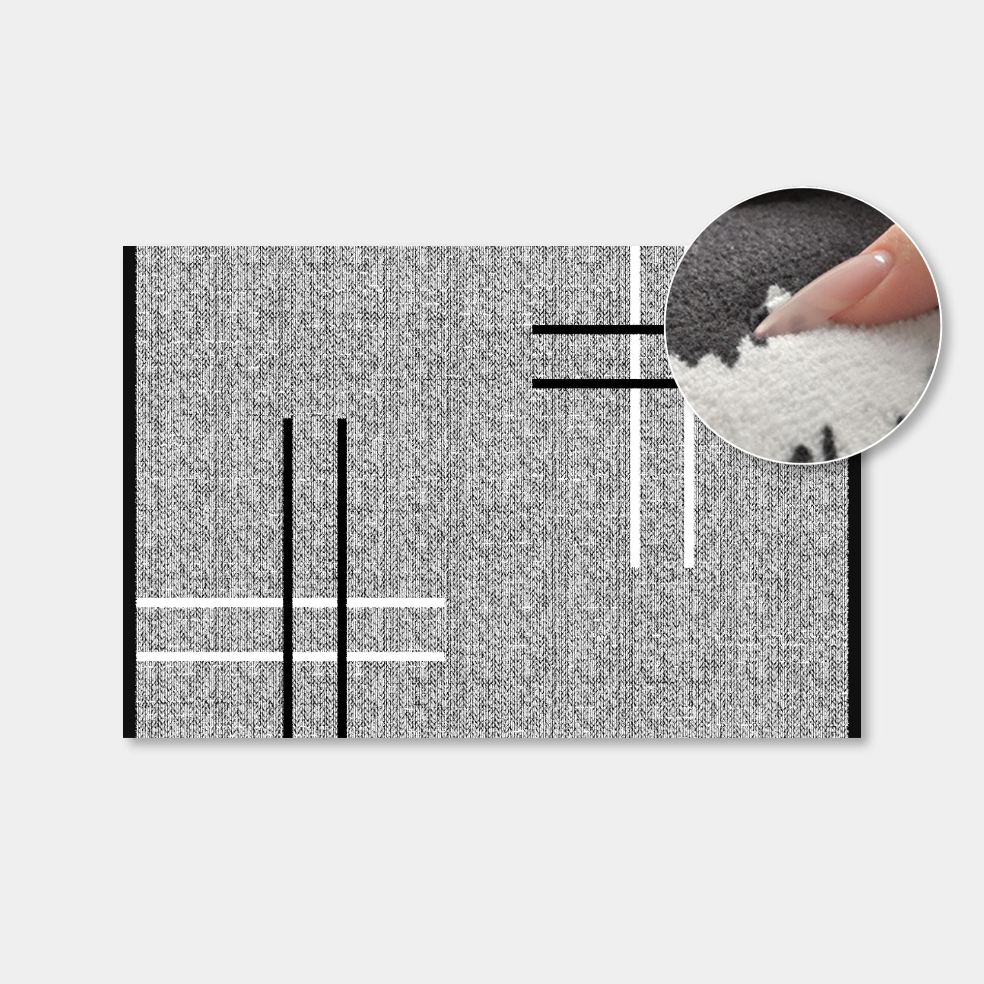 A rectangular gray and black textured rug or mat shown on a light gray background, with a circular inset demonstrating the soft white pile texture from above.