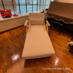 Beige sofa bed in a room with wooden flooring and a piano.