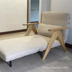 Beige sofa bed with wooden legs in a room setting