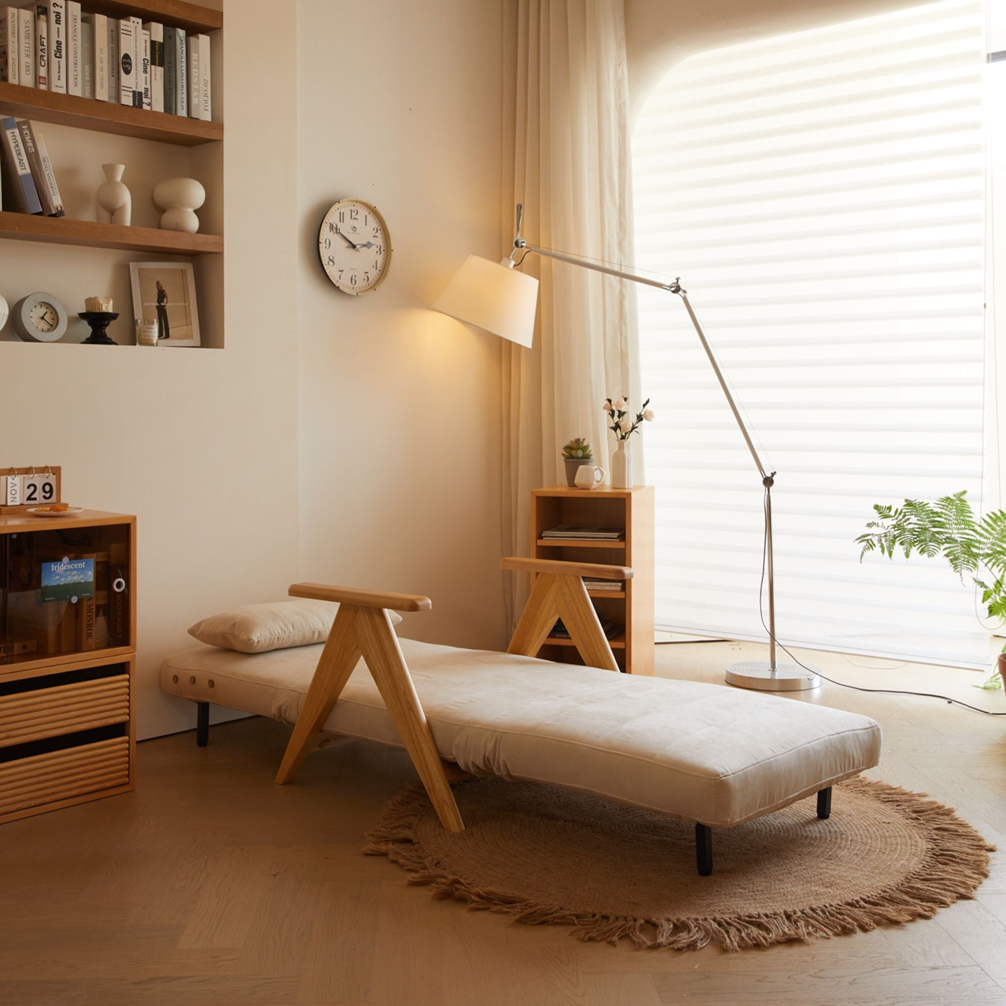 Corona fabric sofa bed in bed mode with a bookshelf, and floor lamp.