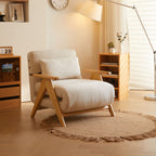 Beige armchair in a living room with wooden shelves and a lamp.