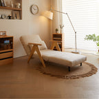 Beige chaise lounge in a modern living room with wooden shelves and a lamp.