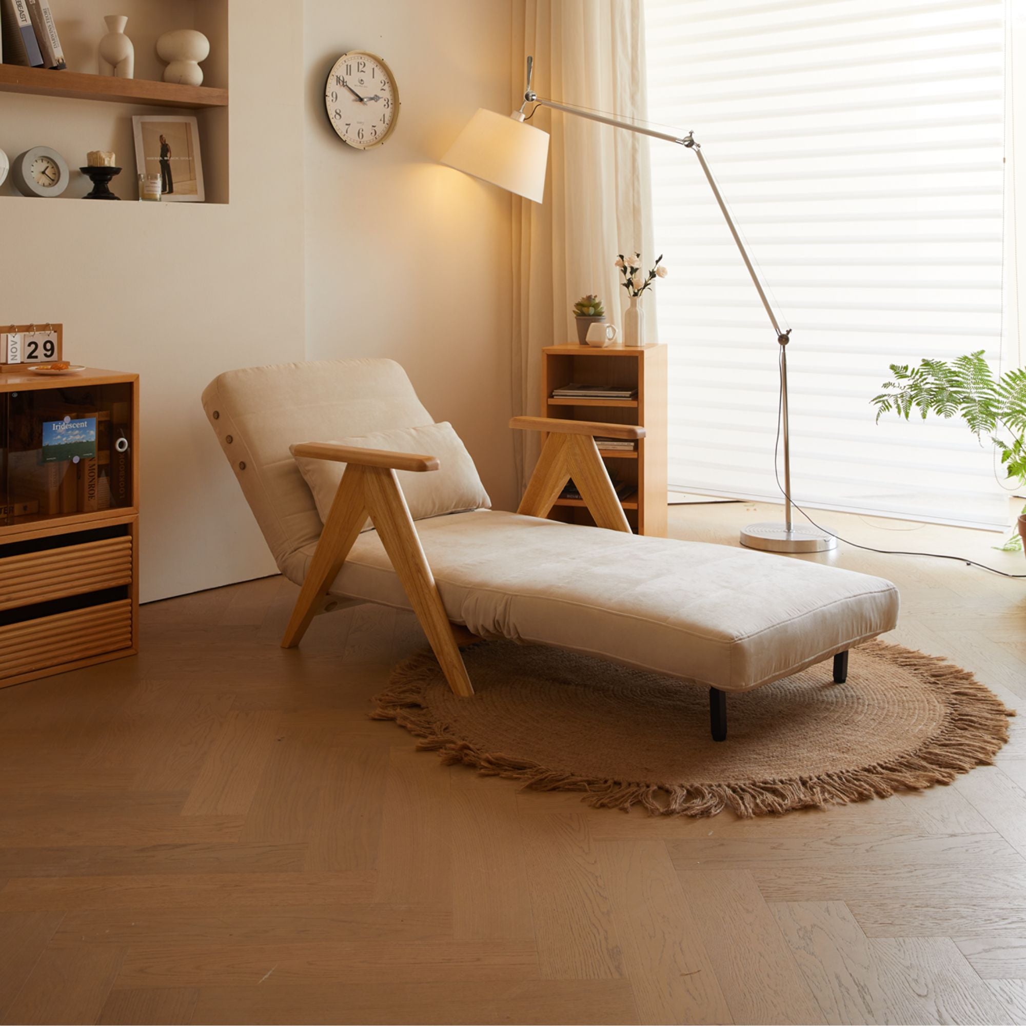 Beige chaise lounge in a modern living room with wooden shelves and a lamp.