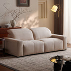 Beige sofa in a living room setting with a lamp, vase, and decorative items.