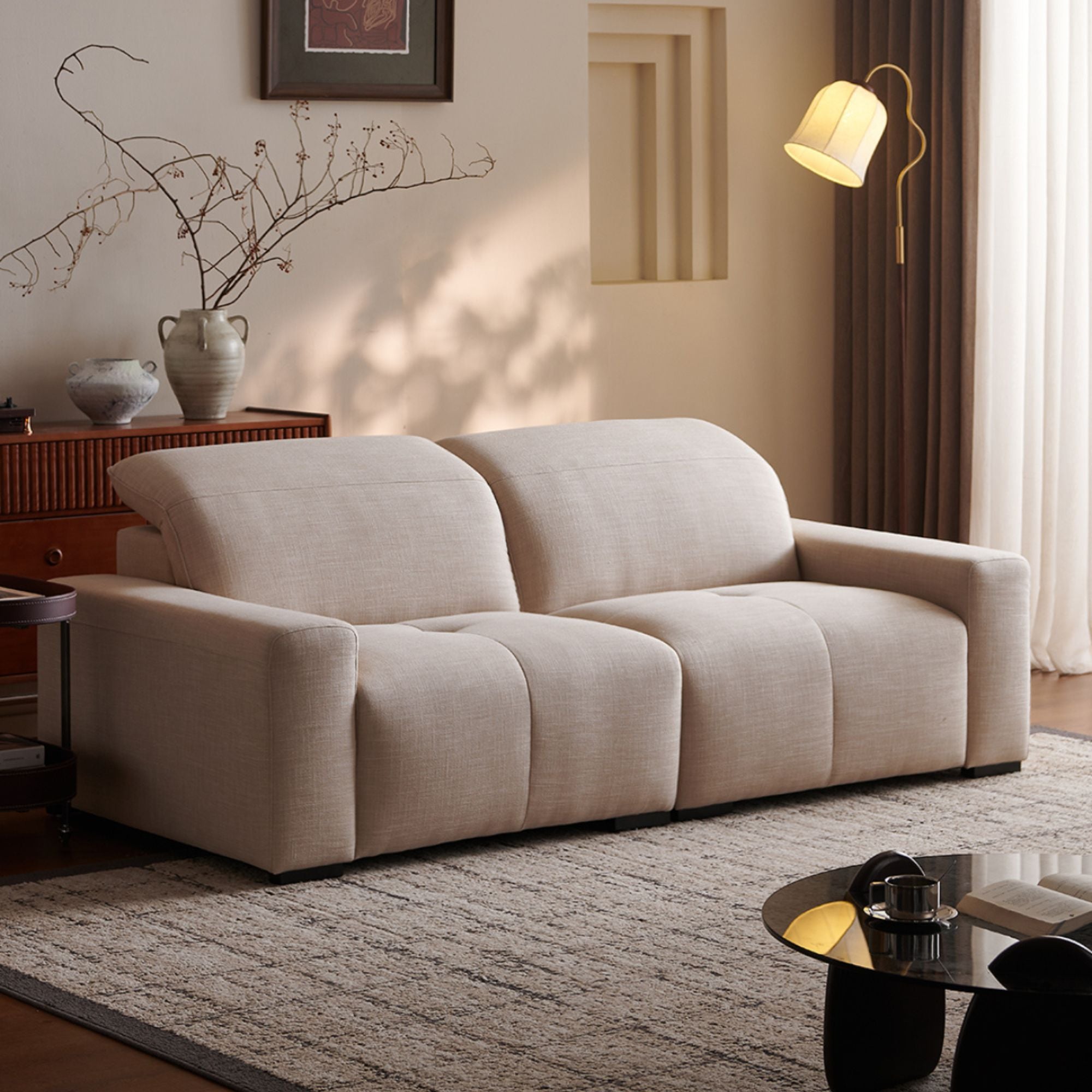 Beige sofa in a living room setting with a lamp, vase, and decorative items.