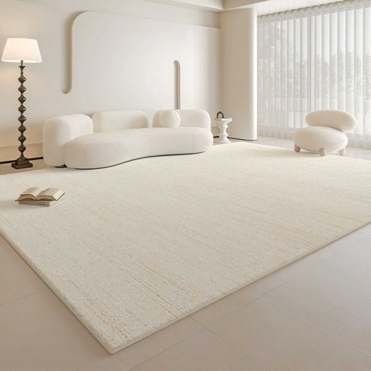 Modern living room with a large white rug, white sofa, and minimal decor.