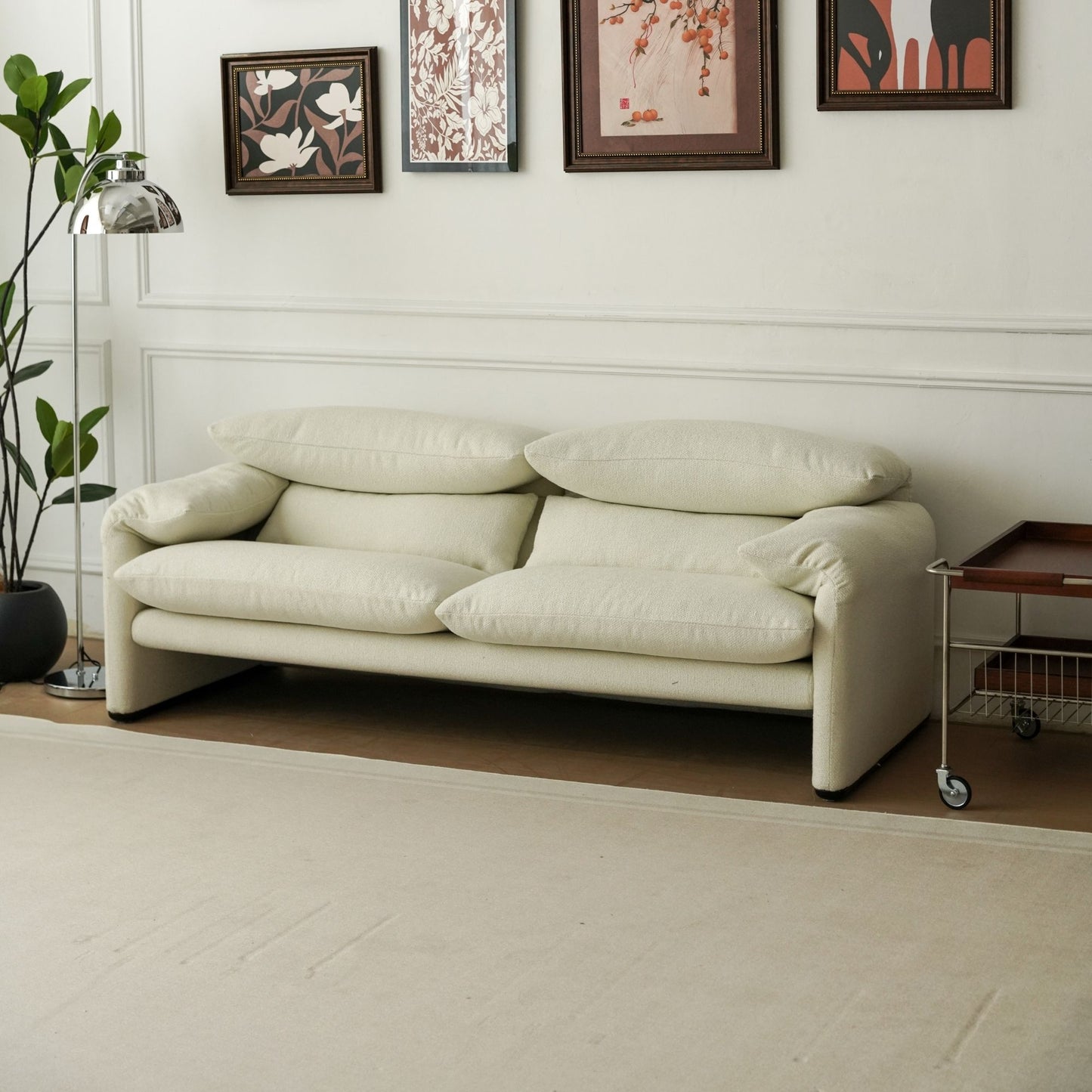 Beige sofa in a living room with decorative wall art and a plant.