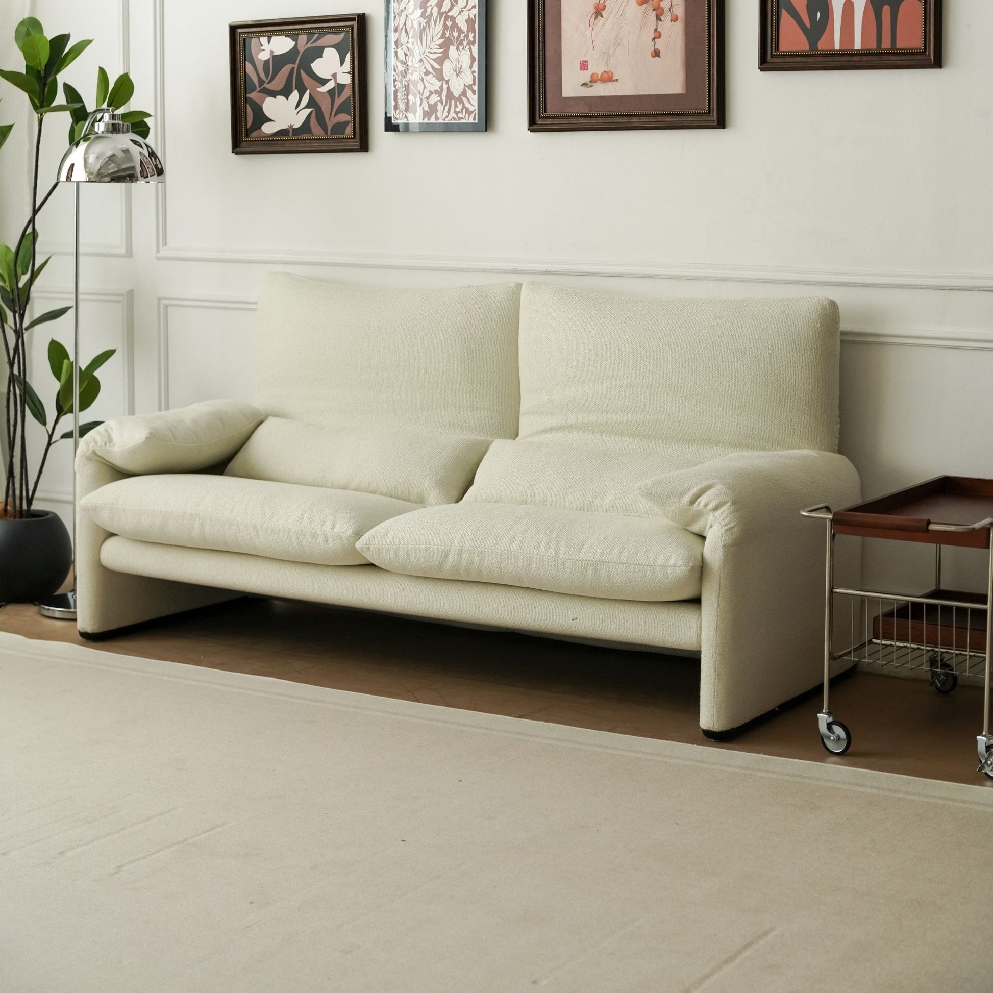 Beige sofa in a room with framed pictures on the wall.