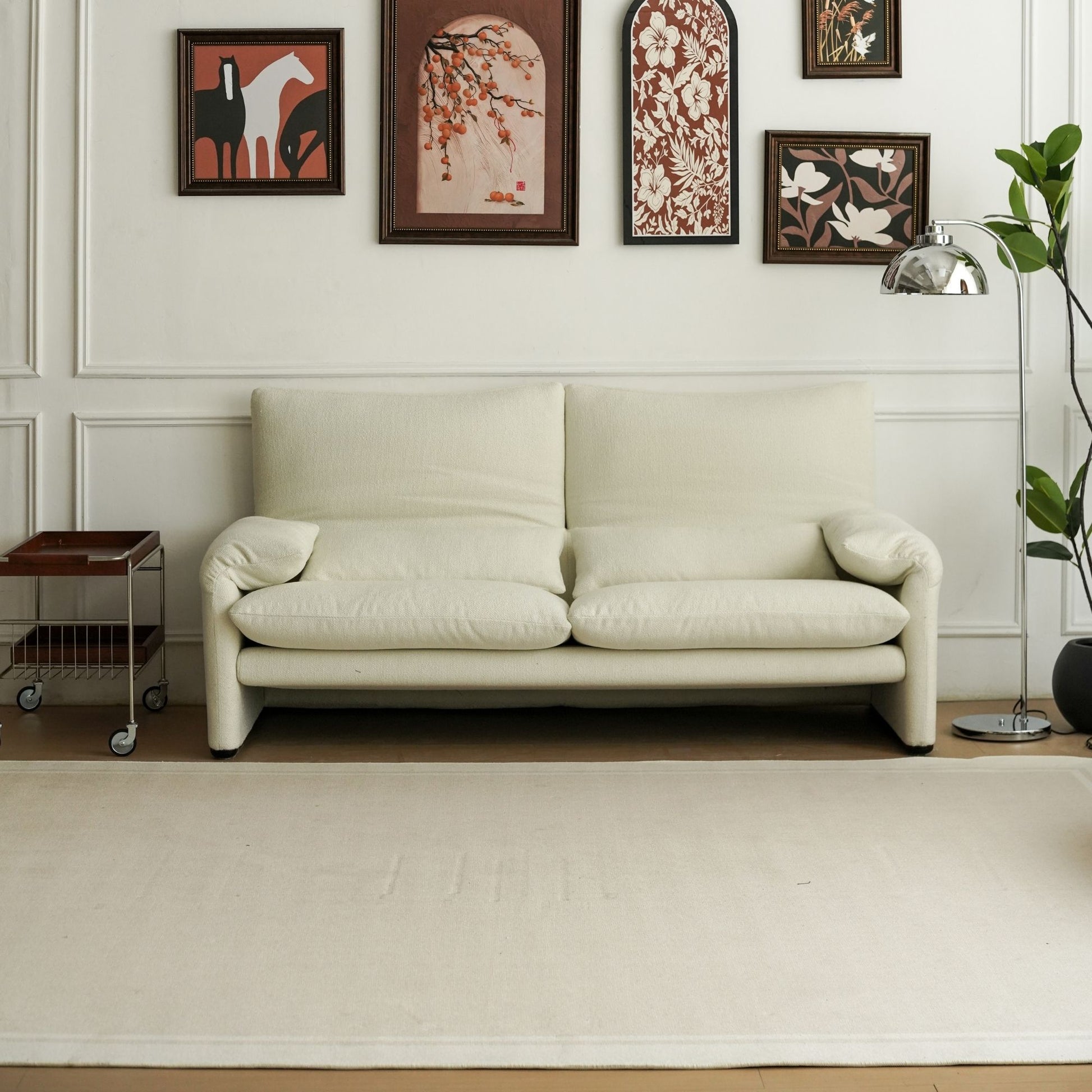 Beige sofa in a room with decorative wall art and a plant.