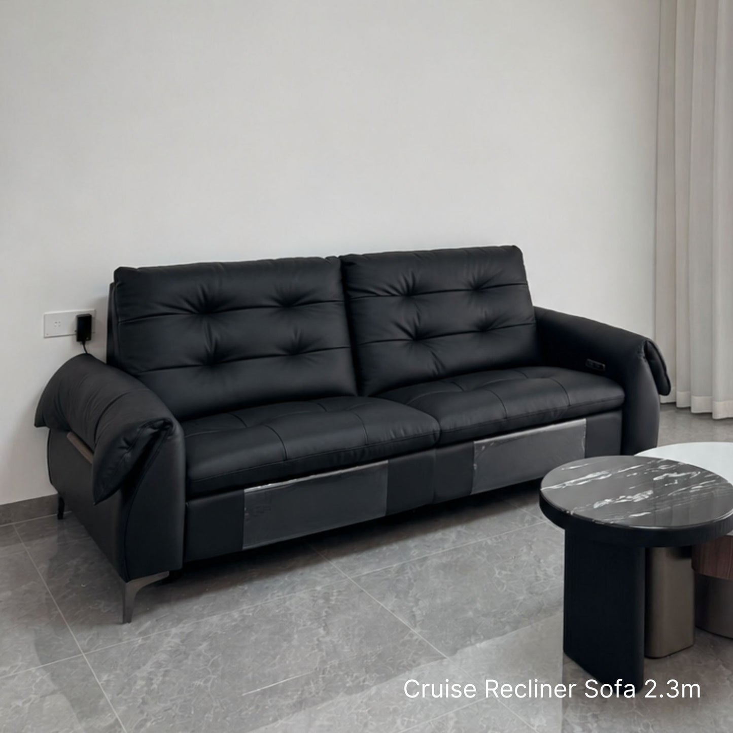 Black recliner sofa in a room with a marble table.