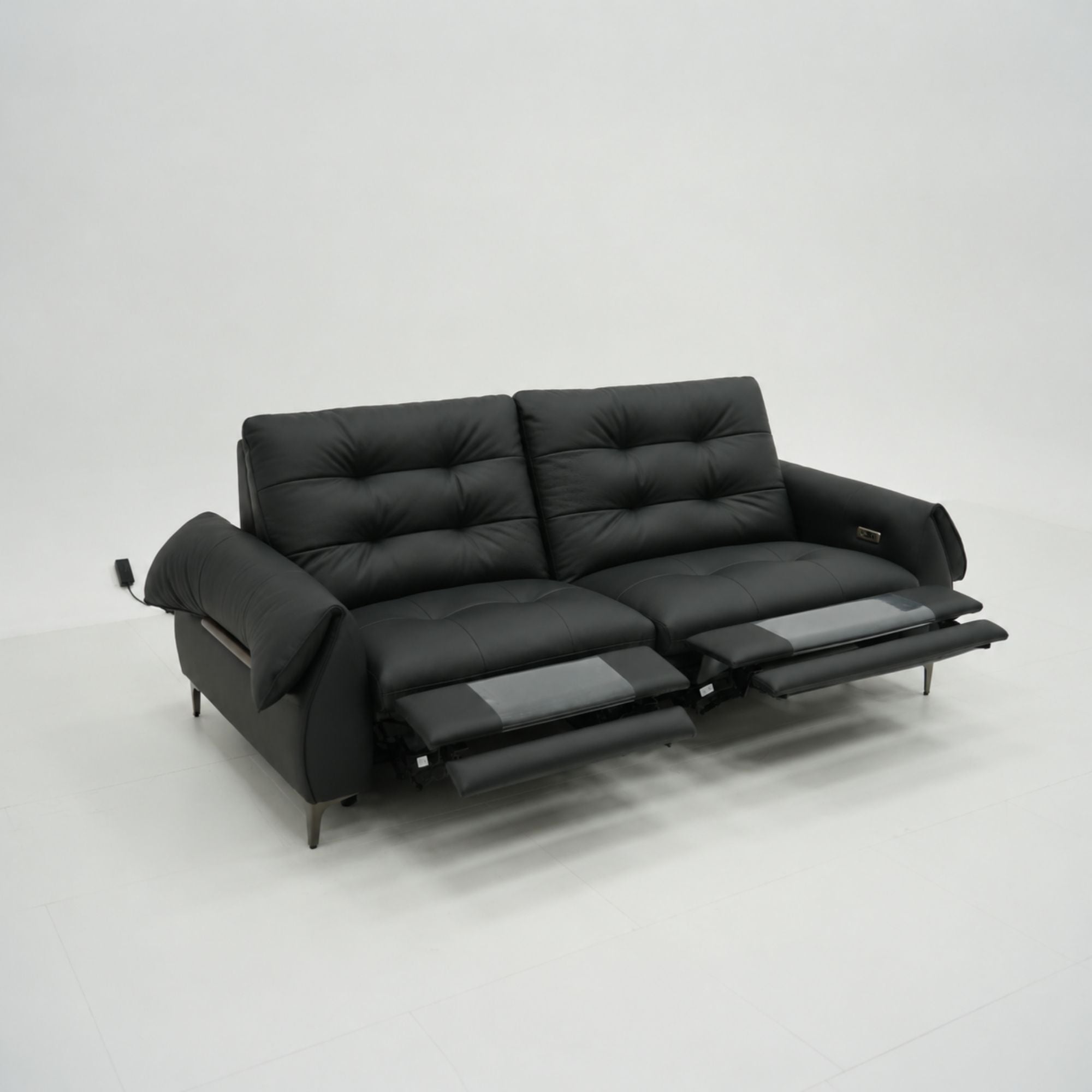 Black leather sofa with reclining feature on a white background