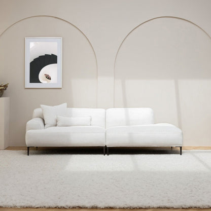 White sofa in a minimalistic room with a framed picture on the wall.