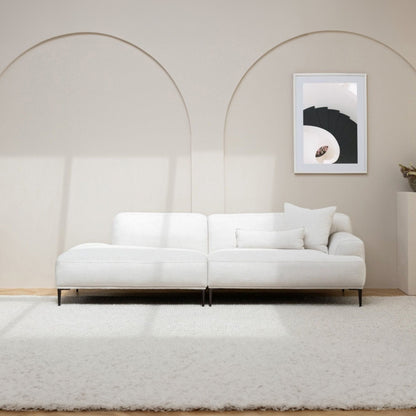 White sofa in a minimalistic room with a framed picture on the wall.
