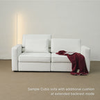 White sofa with additional cushion and red blanket in a minimalistic room.