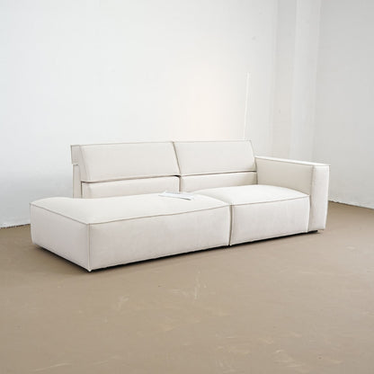 White sofa in a minimalistic room with white walls and a beige floor.