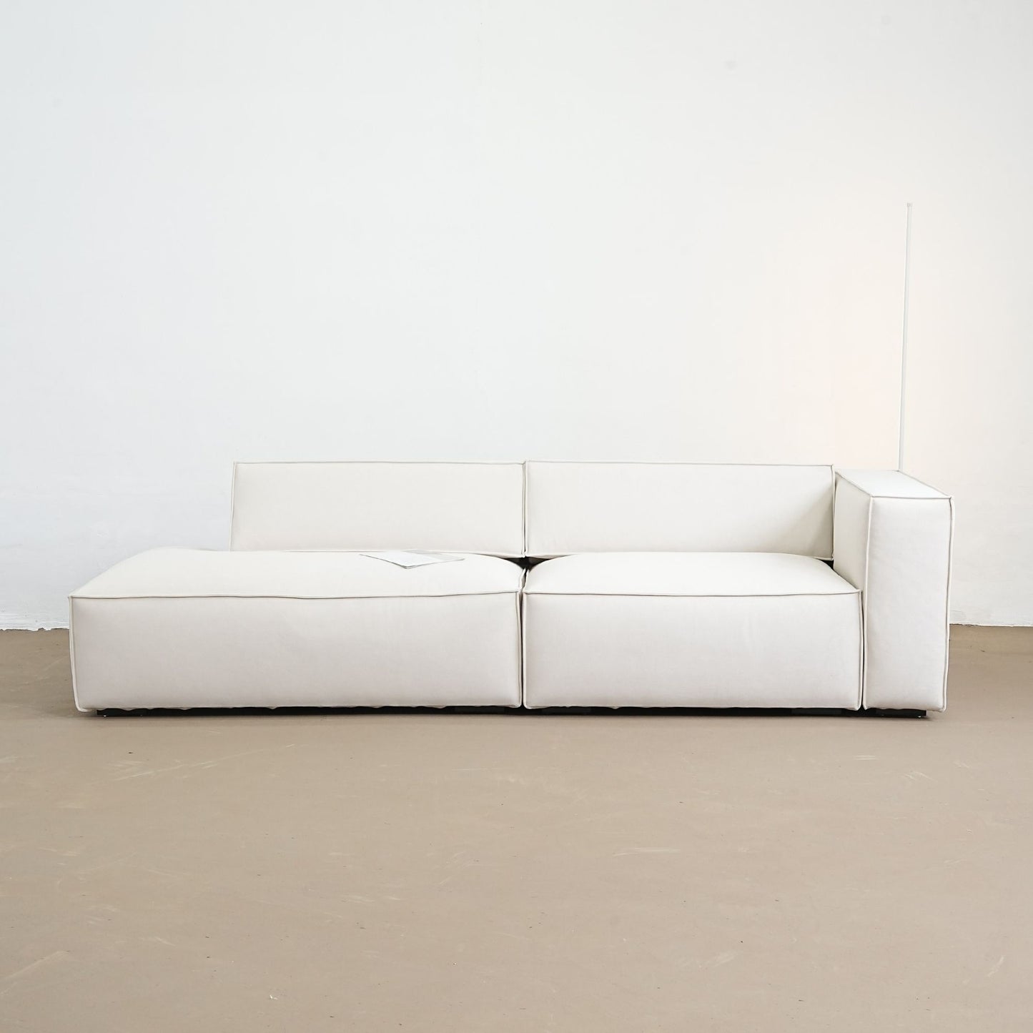 White modular sofa on a beige floor with a white wall background