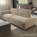 Beige sectional sofa in a living room setting with a dining area in the background.