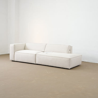 White sofa in a minimalistic room with white walls and a beige floor.