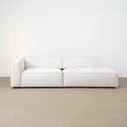 White sofa on a beige floor with a white wall background