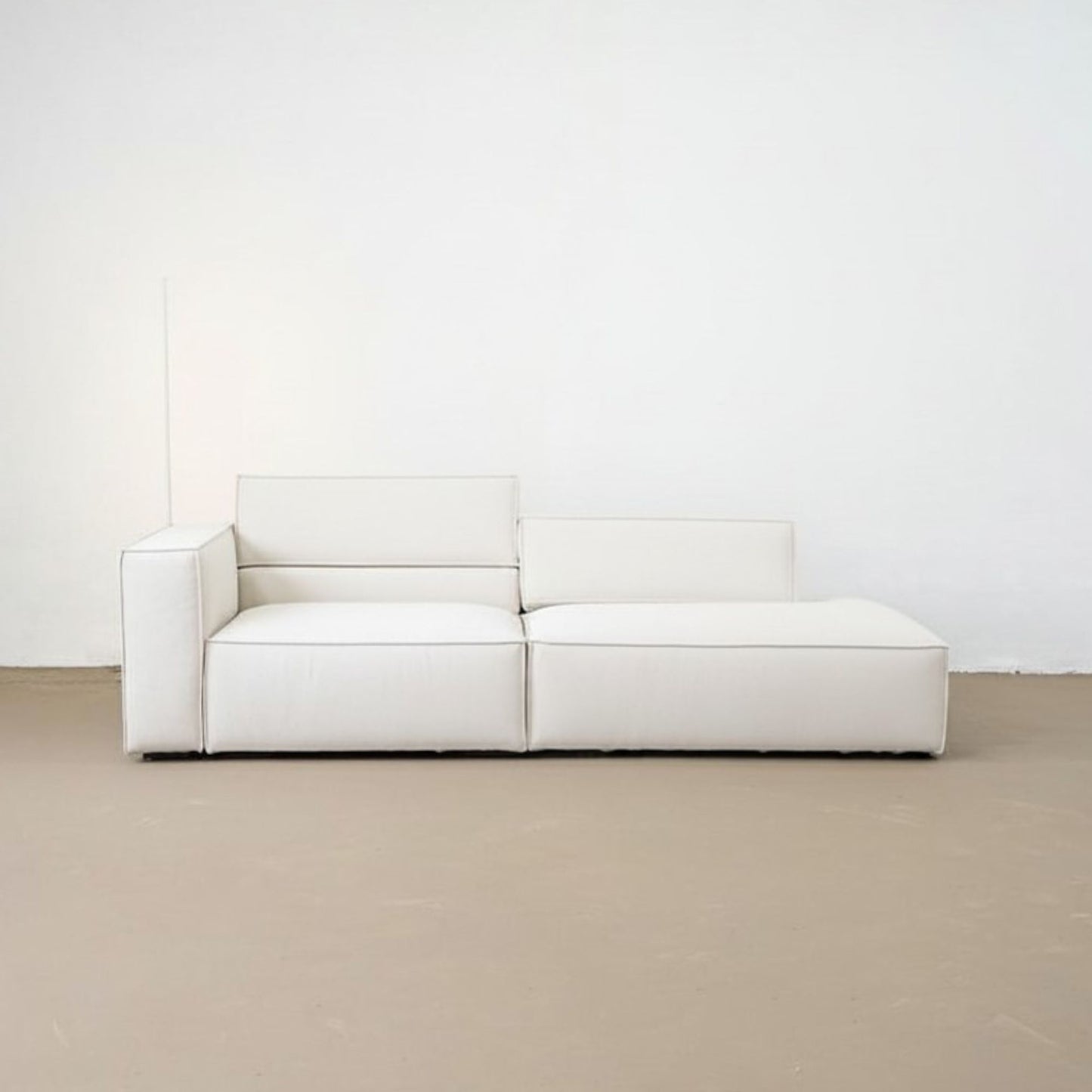 White modular sofa against a white wall on a beige floor