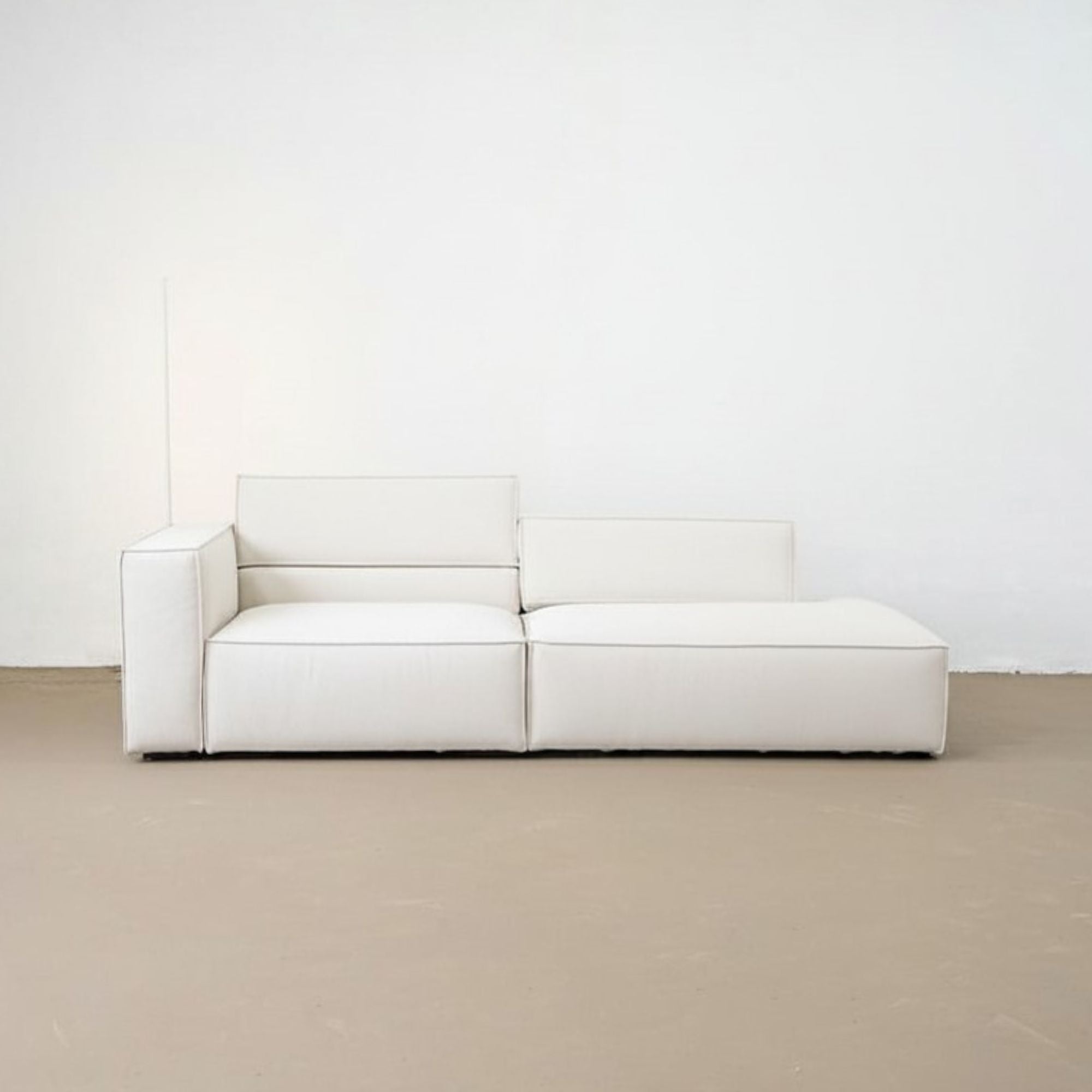 White modular sofa against a white wall on a beige floor