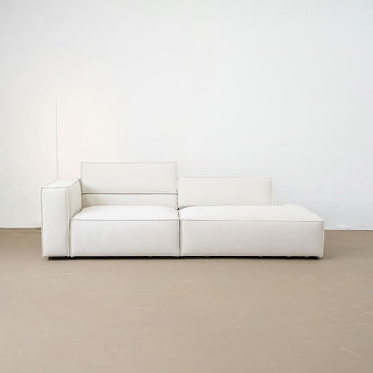 White modular sofa against a white wall on a beige floor