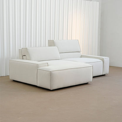 White modular sofa in a minimalistic room with white curtains.