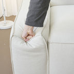 Hand pressing down on the armrest segment of the Cubix adjustable backrest sofa