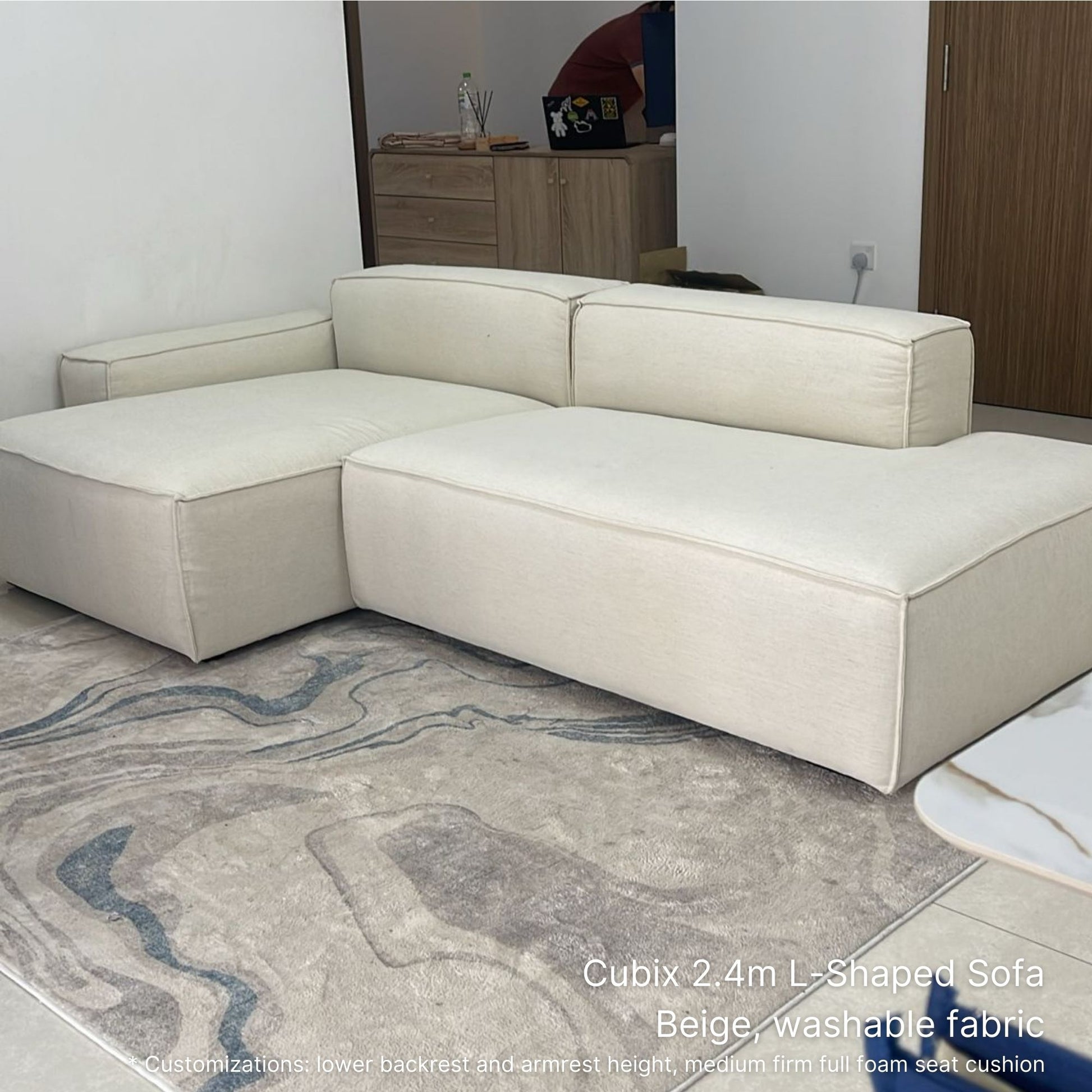 Cubix beige L-shaped washable fabric sofa on a patterned rug with a neutral background