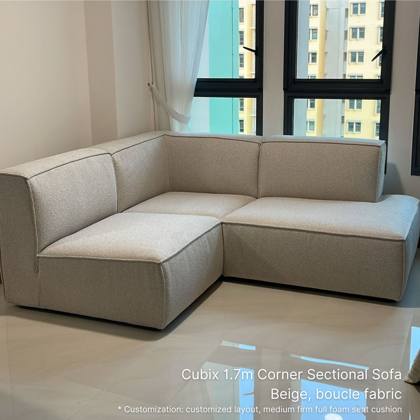 Beige boucle fabric corner sectional sofa in a room with large windows.