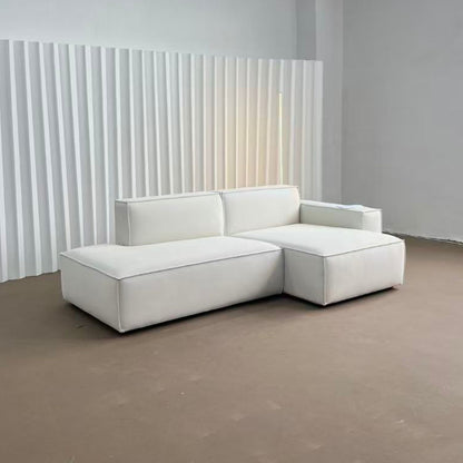 White sectional sofa in a minimalistic room with a textured wall.