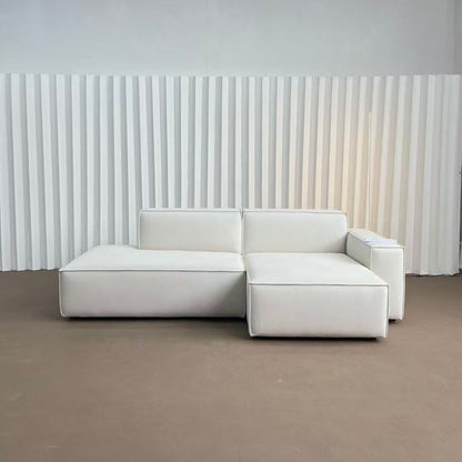 White sectional sofa against a white paneled wall.