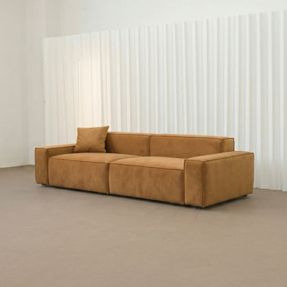Brown sofa in a minimalistic room with white walls and gray floor.